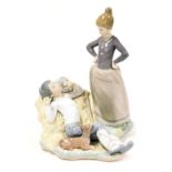 A Lladro porcelain group of a boy awakening from his slumber, being confronted by a girl with her ha
