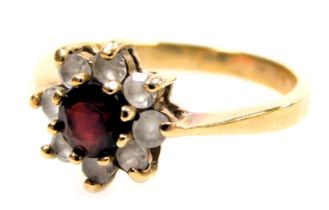 A 9ct gold flowerhead cluster ring, with a central brilliant cut ruby, surrounded by eight tiny whit