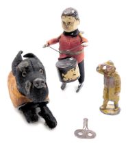 A Schuco clockwork dog, in a tartan jacket, together with a drummer, with keys and a lead figure of