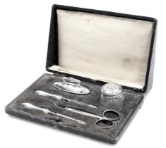 A George V silver, steel and glass five piece manicure set, with stipple engraving, oval shield rese