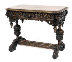 A Victorian oak library table, with a foliate carved and canted rectangular top, above a foliate car