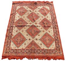 A caucasian cream ground rug, the central field decorated with floral medallions, within repeating f