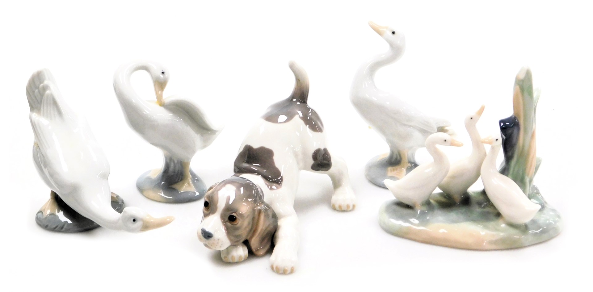 A LLadro porcelain figure of a spaniel puppy, together with Lladro and Nao porcelain figures of gees
