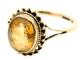 A 9ct gold and citrine ring, oval cut, in a high claw setting size O, 2.3g.