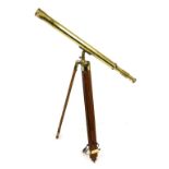 A brass cased telescope, on a wooden tripod stand, telescope 99cm long.