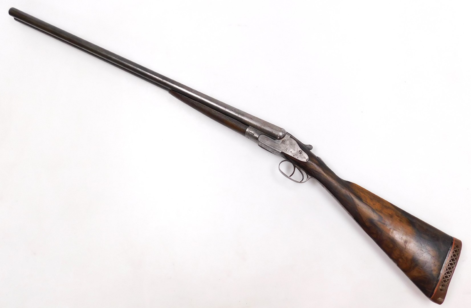 A 12 bore side by side shotgun, maker unknown, with a walnut stock, 110cm long. NB. A current valid