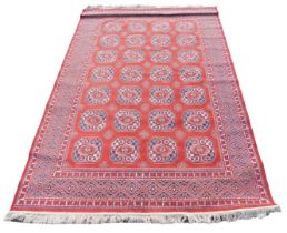 A Bokhara red ground rug, the central field decorated with four rows of twenty eight medallions, wit