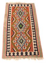 A Turkish kilim rug, the central red field decorated with three blue medallions, chevrons and other