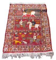 A Persian Shiraz figural red ground rug, the upper panel with a winged and figural horse and mask, c