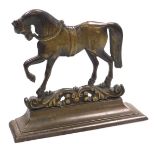 A Victorian brass doorstop, cast as a prancing horse, on a foliate scroll ground, above an outswept