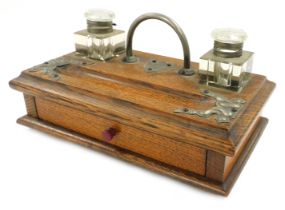 A Victorian oak and plate mounted desk stand, with two cut glass inkwells, and pen recess, over a fr