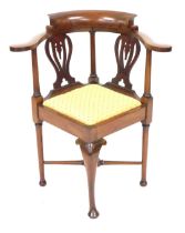 A late Victorian mahogany corner elbow chair, with a drop in seat, raised on a front cabriole leg, a