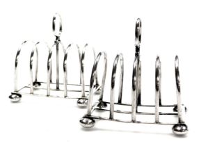 A pair of George V silver four division toast racks, each raised on bun feet, Birmingham 1930, 5.43o