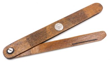 A vintage mid century oak pocket knife display shelf, with a circular white metal plaque engrave Geo