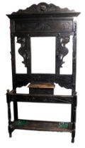 A Victorian ebonised hall stand, with a lion's head carved crest rail, above a central mirror, inset