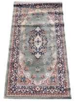 A Shirvan style green ground rug, with a central floral medallion within repeating floral borders, 1