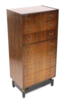 A mid century G Plan teak chest, of seven drawers, raised on a brass capped ebonised box base, 126cm