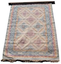 A Turkish kilim cream ground rug, decorated with eight central floral motifs, within repeating geome