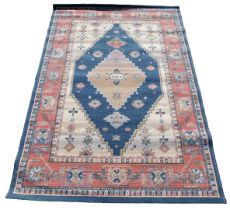 A Turkish blue and cream ground rug, decorated with stylised floral motifs, within repeating floral