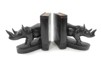 A pair of wooden book ends, carved as a book and rhinoceros, 17cm high.