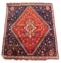 A Kashgai red and blue ground rug, the central red field decorated with birds and flowers, against a