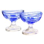 A pair of early 20thC Moser dark blue faceted pedestal salts, of boat form, etched mark, 9cm wide.