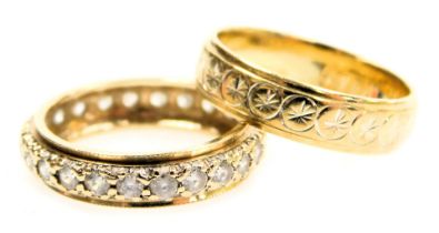 A 9ct gold wedding band, with engraved medallion decoration, 3.10g and a 9ct gold eternity ring set
