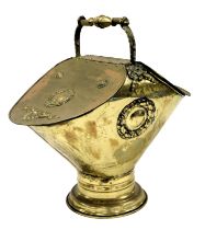 A Victorian brass neo classical style double coal scuttle, with embossed wreath and foliate motifs,