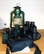 Two pairs of binoculars and a a hurricane lamp.