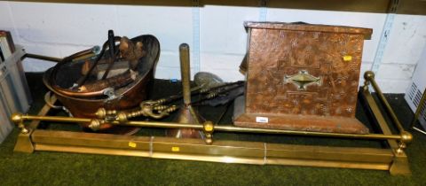 Brass and copper wares, including a fire fender, helmet shaped coal scuttle, fire irons and a copper