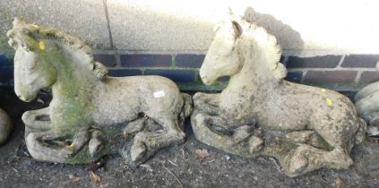 Two garden ornaments in the form of recumbent foals.