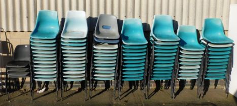 A large quantity of plastic stacking chairs.