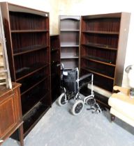 Four bookcases and a folding wheelchair.