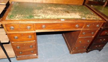 A twin pedestal kneehole desk of nine drawers, with green leatherette top.