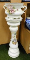 A pottery jardiniere and stand, encrusted with flowers.
