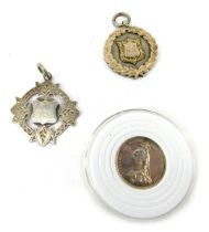 A Queen Victoria silver shilling, dated 1887, together with two silver fobs, one with gilt decoratio