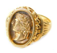 A 9ct gold signet ring, the oval panel set with a warrior's head, in raised relief with V splayed an