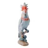 A Royal Dux porcelain figure of a Cockatoo, modelled standing on branch with leaves, raised triangle