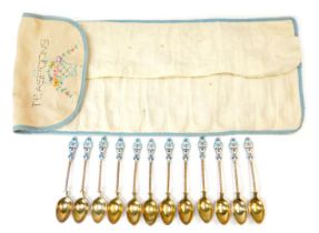 A set of twelve early 20thC Russian silver gilt and enamel coffee spoons, each with a shaped top, on