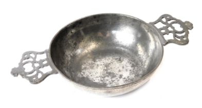 A late 19thC pewter two handled shallow bowl, with pierced and moulded handles, stamped E and Englan