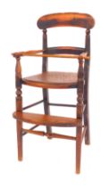 A 19thC elm child's highchair, with solid rail and turned supports, pierced later seat, on turned le