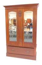 An Art Nouveau walnut wardrobe, the top with a moulded edge above two mirrored doors, enclosing bras