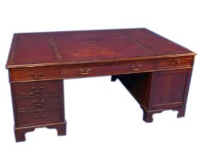 An Edwardian mahogany partner's desk in George III style, with a tooled red leather top, each side w