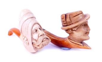 Two meerschaum pipes, one decorated with the head of a Middle Eastern gentleman with amber cheroot,
