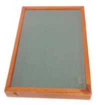 A 20thC mahogany tabletop display case, the hinged lid inset with a glass panel enclosing a green fe
