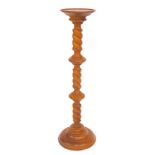 A 20thC hardwood jardiniere stand, the circular top raised on a three part turned column, on a circu