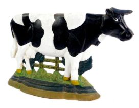 A late 20thC painted cast iron doorstop, with cow and fence, on a stepped base, 21cm high.