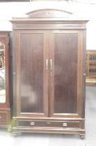 A 19thC mahogany wardrobe, with a raised arched top above a moulded edge with two panelled doors enc