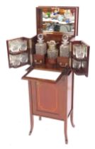 An Edwardian mahogany drinks cabinet, the hinged inlaid top with a moulded edge opening to reveal th