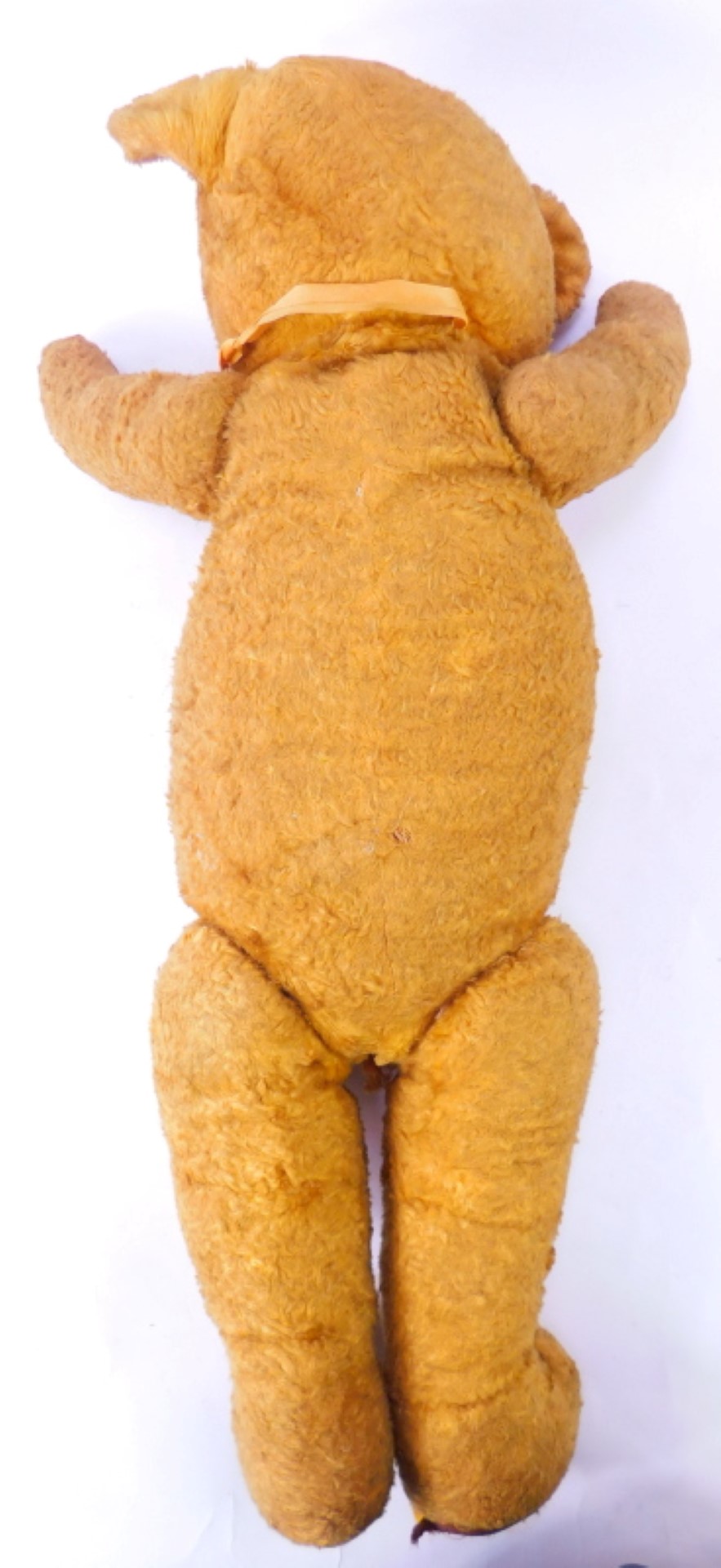 An early 20thC plush blonde jointed straw filled Teddy bear, with amber glass eyes, and pad paws and - Image 2 of 4